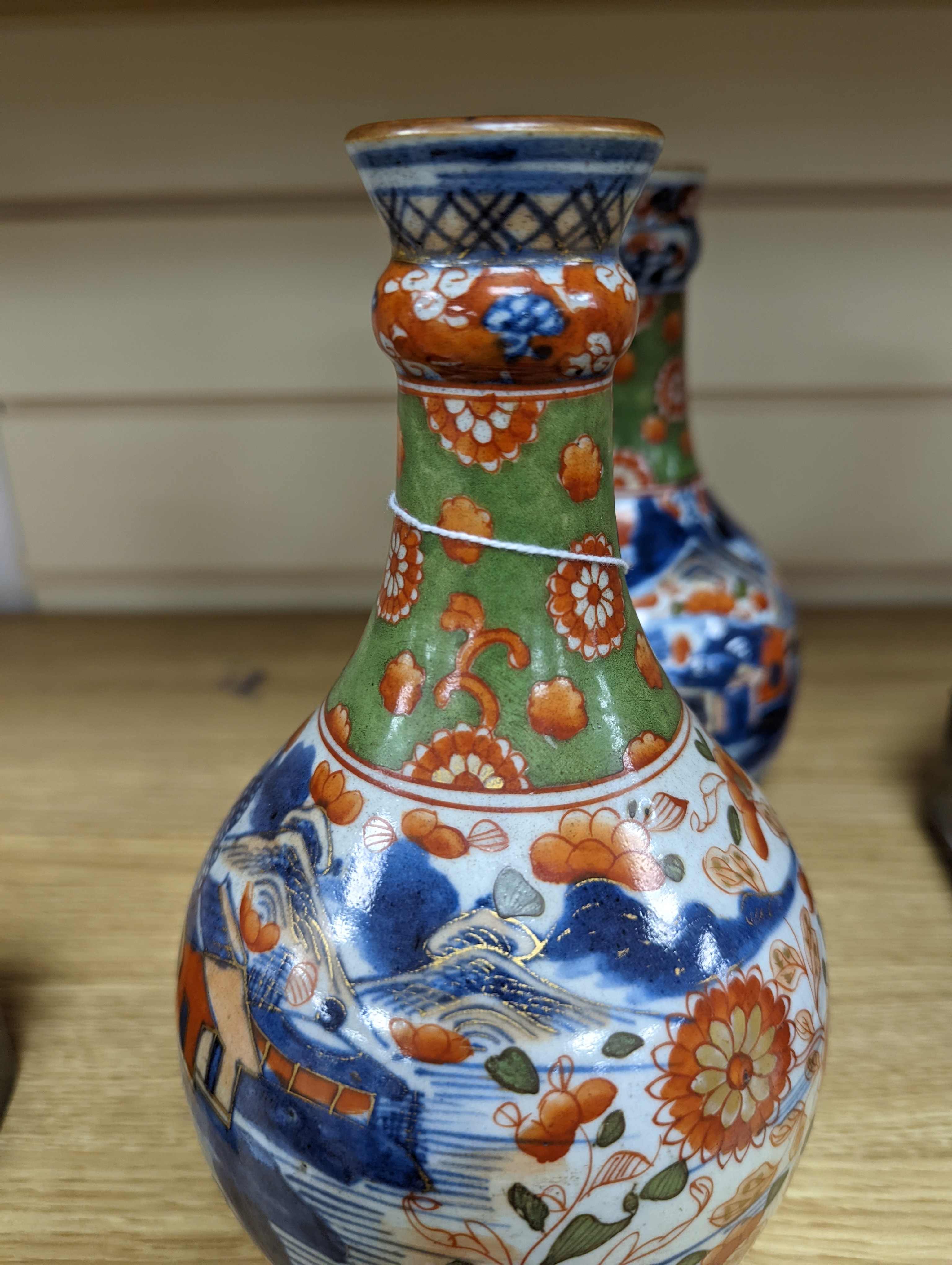 A pair of 18th century Chinese clobbered blue and white bottle vases 23cm